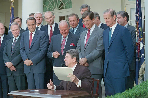 President Ronald Reagan signs the Gramm-Rudman-Hollings Act in December 1985, flanked by its sponsor