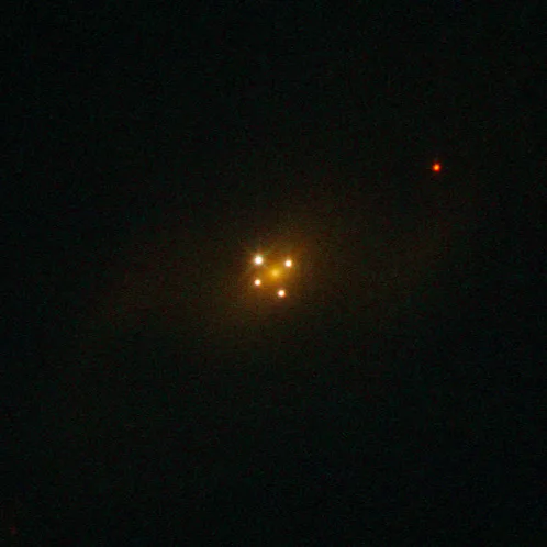 The Einstein Cross is a rare and stunning example of gravitational lensing, where a massive foregrou